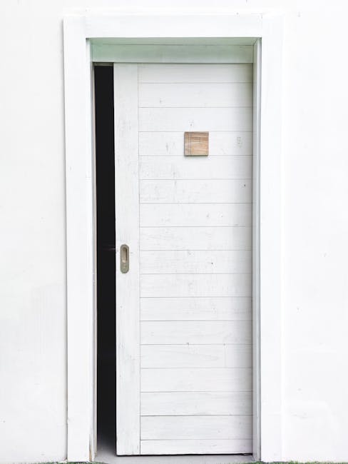 Elegant minimalist design featuring a white sliding door slightly open on a white wall, perfect for modern architecture concepts.