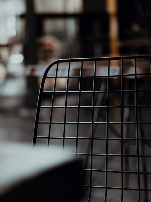 Wire mesh chair in a dimly lit café, showcasing modern industrial interior design aesthetics.