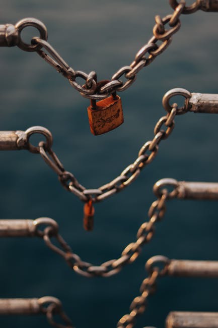 Close-up of a rusty padlock on chains, symbolizing security and protection.