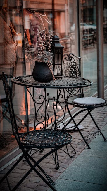 Charming vintage wrought iron table and chairs set against a city street backdrop, ideal for rustic outdoor cafe ambiance.