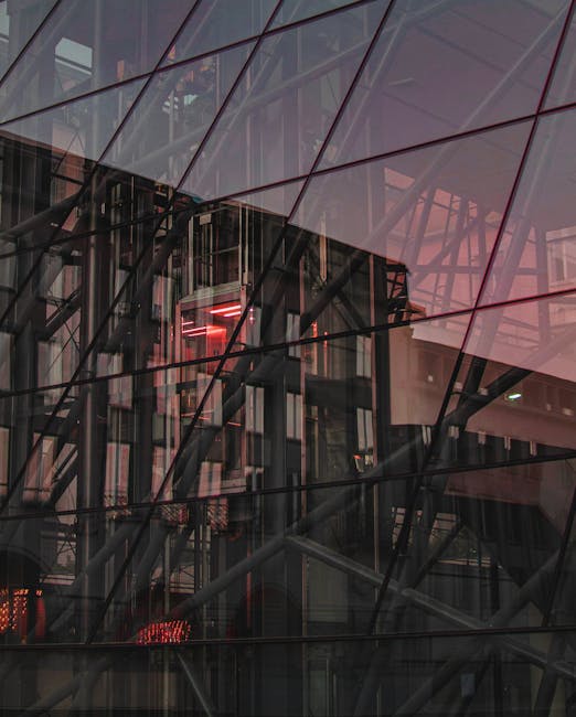 Abstract reflection of urban architecture on glass at sunset, showcasing modern design.