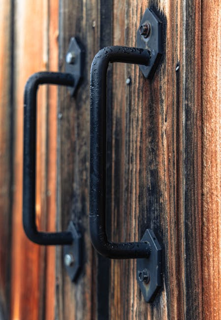 Detailed close-up of metal handles on a rustic wooden door with a vertical layout.