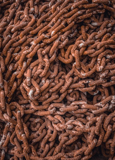 Detailed view of intertwined rusty metal chains forming an abstract pattern.