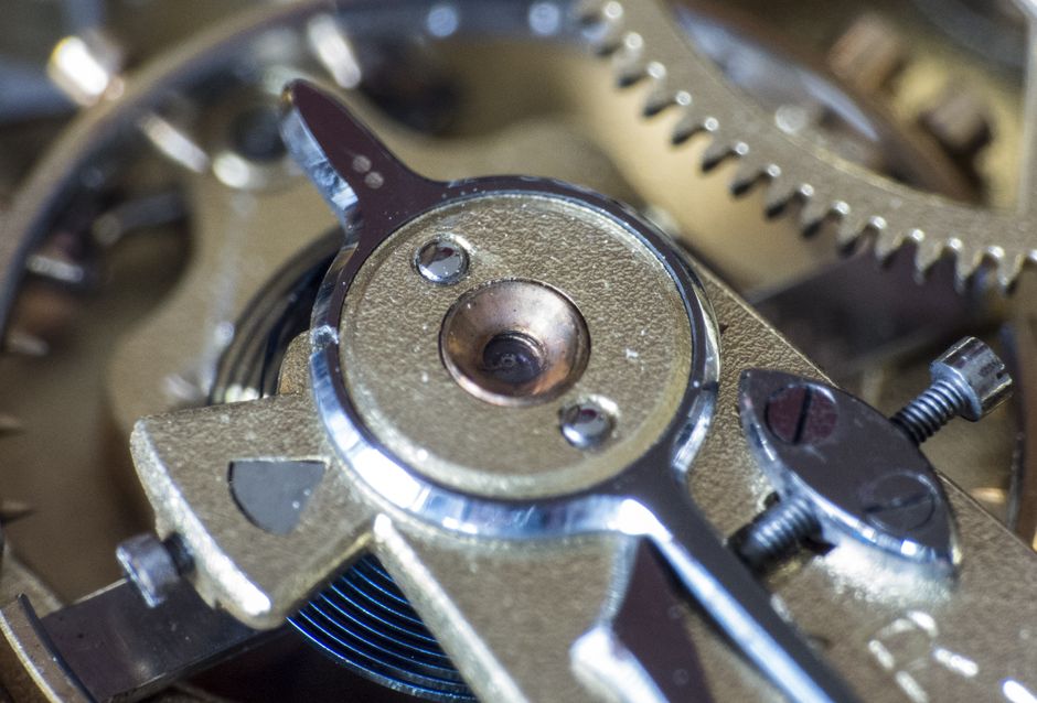 Close-up view of a watch's metallic gears showcasing intricate mechanical details and synchronized movement.