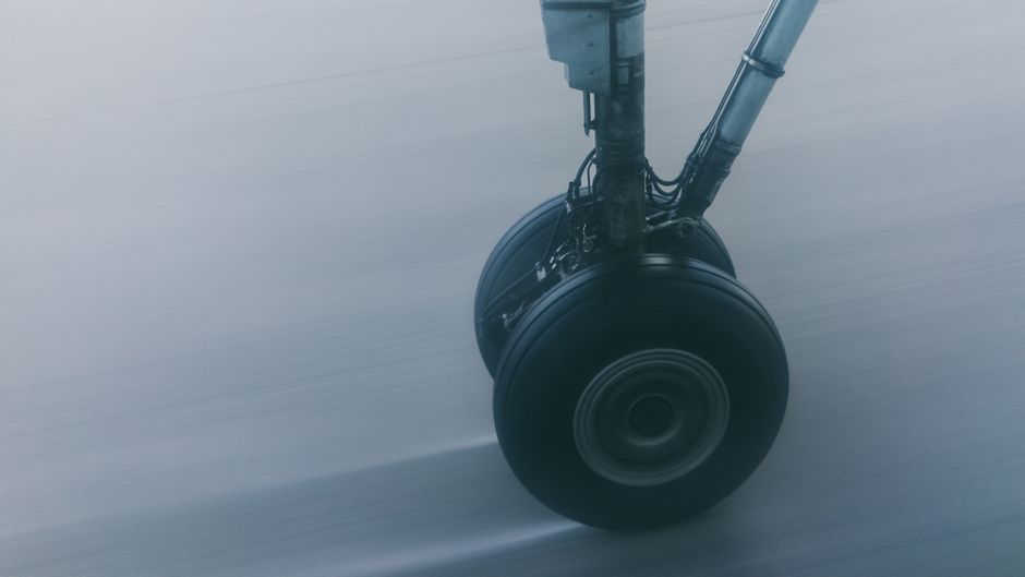 Close-up of airplane landing gear in motion during takeoff or landing, showcasing power and technology.