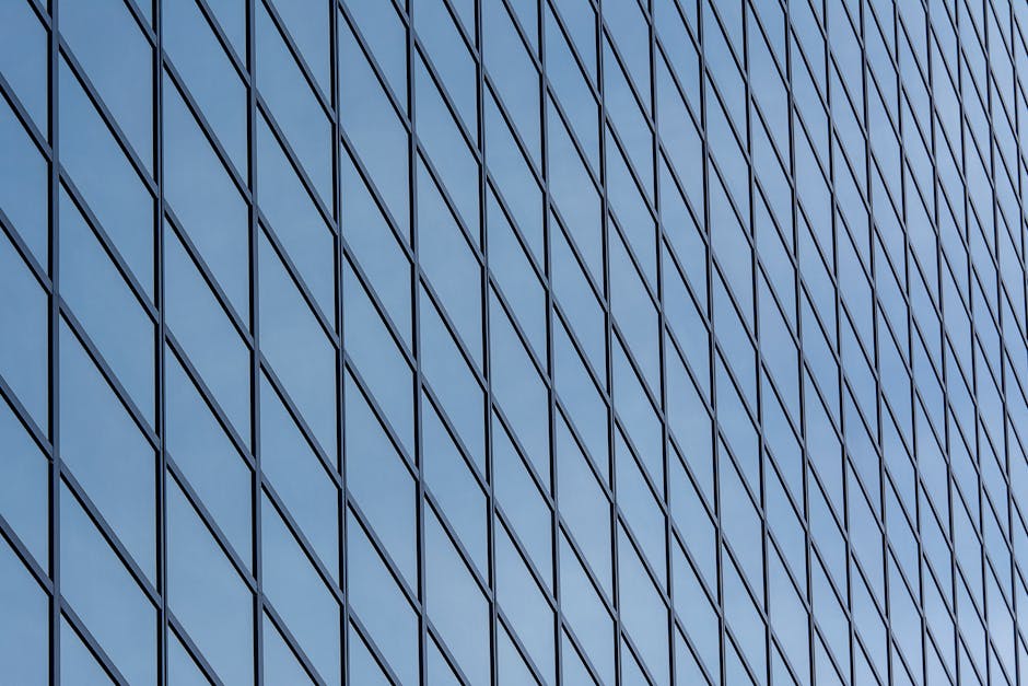 Close-up of a modern glass skyscraper facade in Rotterdam with reflections.