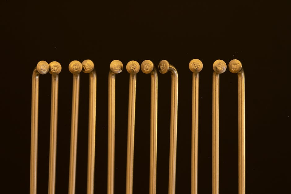 Elegant arrangement of golden metal poles casting shadows on a dark background.