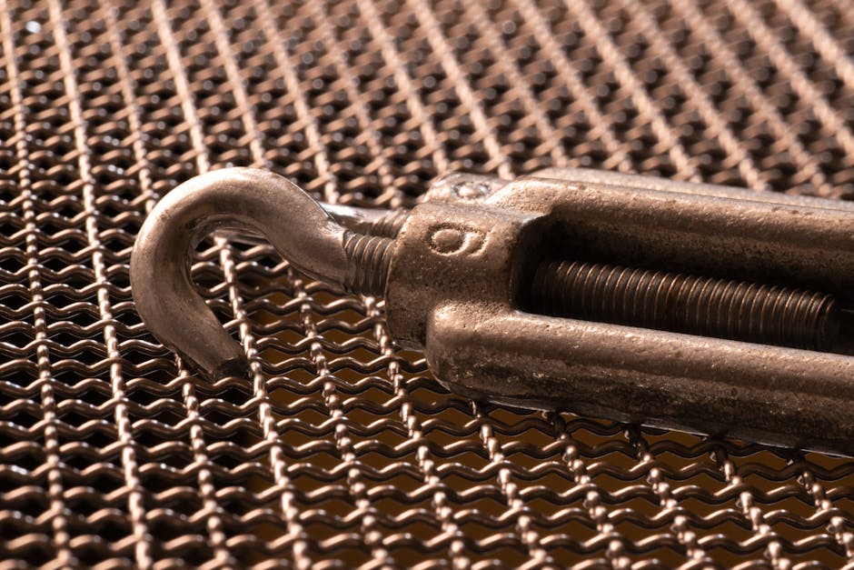 Detailed image of a metal hook on intricate woven mesh, showcasing industrial textures.