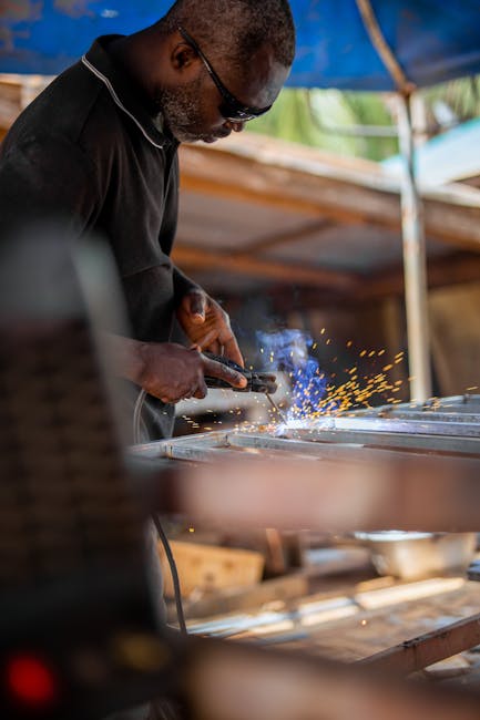 An experienced welder skillfully working with metal, creating bright sparks in an outdoor workshop.