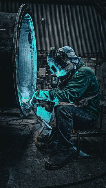 Skilled worker welding inside an industrial factory in Brazil.
