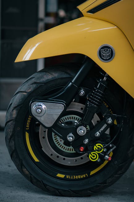 Close-up of a yellow motorcycle wheel showing detailed brake caliper design.