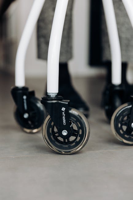 Detailed view of sleek walker wheels on a smooth indoor surface, highlighting mobility aids.