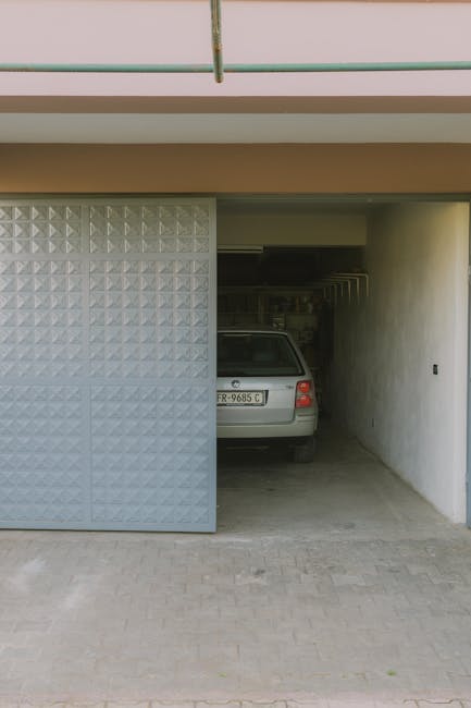 Partially open garage with parked car visible inside, featuring a modern sliding door design.