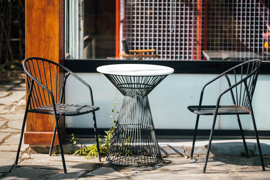 Stylish outdoor café setup featuring modern metal chairs and a round table.