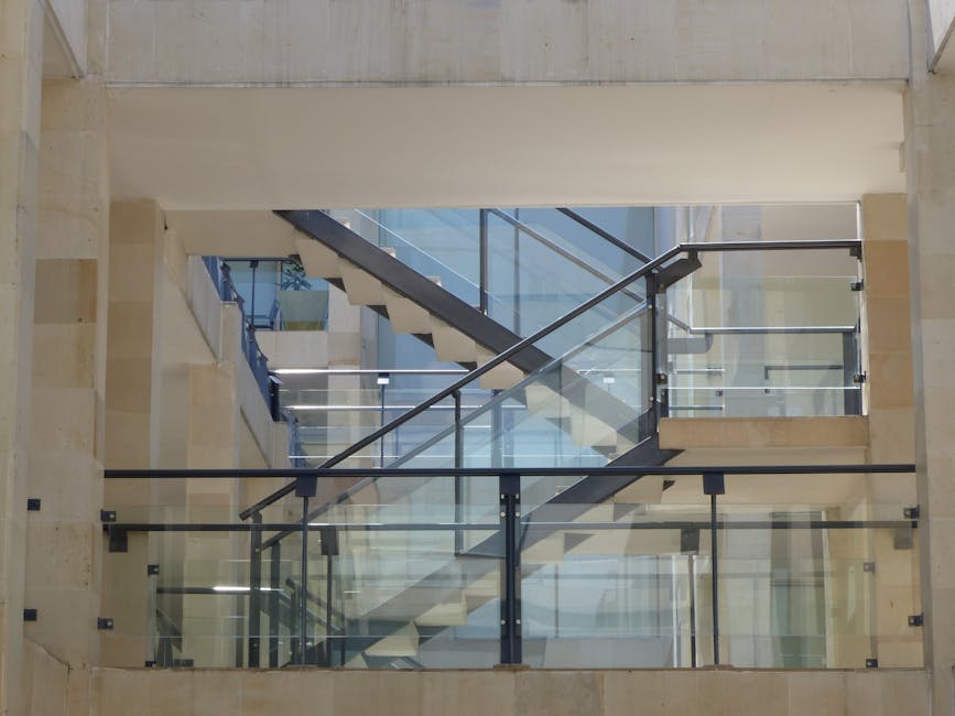 Contemporary design staircase featuring glass railings and metal elements.