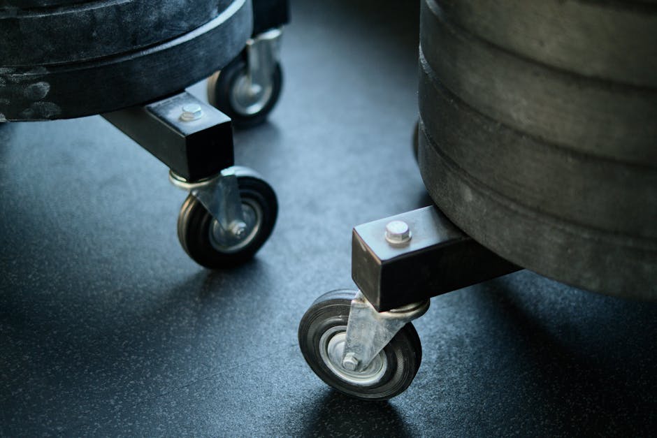 Wheels of gym equipment close-up on a black gym floor, showcasing industrial design.