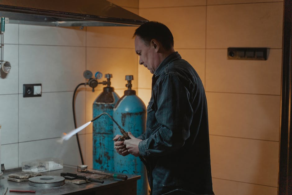 A skilled technician works with a welding torch in an industrial setting, highlighting craftsmanship.