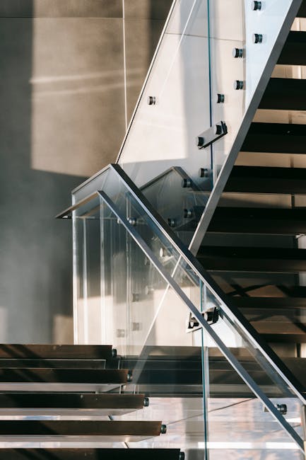 Interior of contemporary apartment with modern stairway with clean glass railings in daytime
