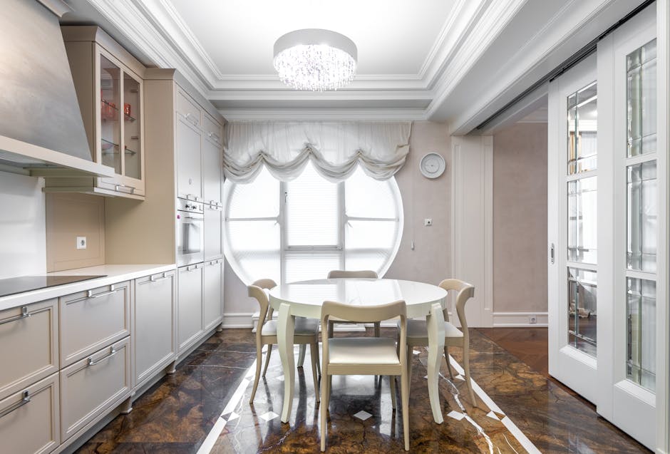 A bright, modern kitchen with a chic dining setup and chandelier.