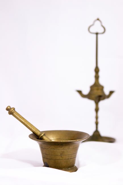 Classic brass mortar and pestle with vintage lamp on a clean white background.