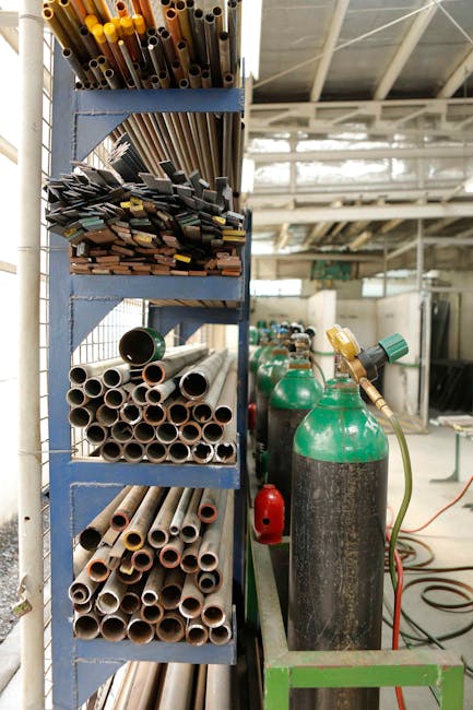 Organized metal workshop with various pipes and gas tanks, perfect for industrial and construction themes.