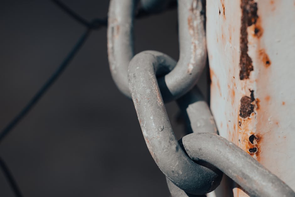Close-up shot of a rusty metal chain wrapped around a weathered post.